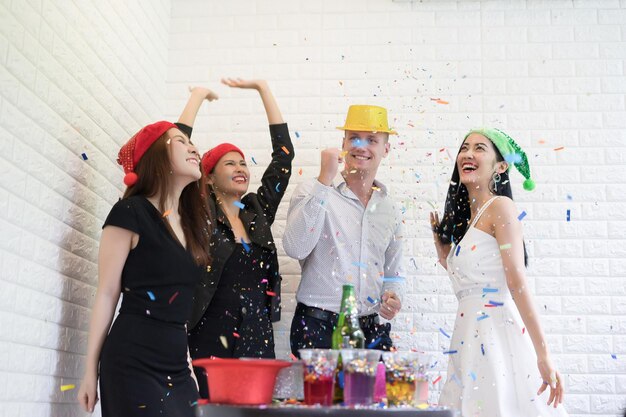 Foto amigos disfrutando de la fiesta contra la pared de ladrillo