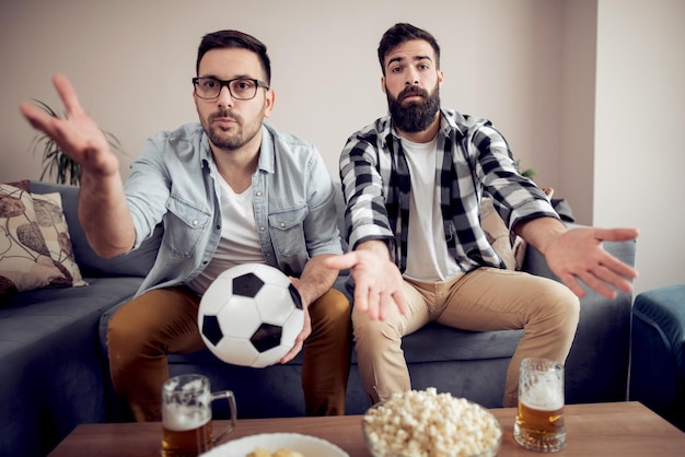 Amigos disfrutando del fútbol en la tele