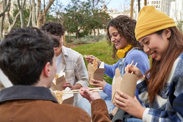 Foto amigos de diversas culturas disfrutan de fideos y risas.