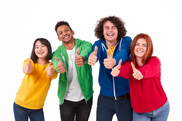 Foto amigos diversos alegres que gesticulan los pulgares para arriba