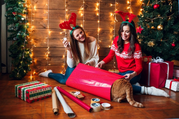 Amigos divirtiéndose mientras preparan decoraciones navideñas