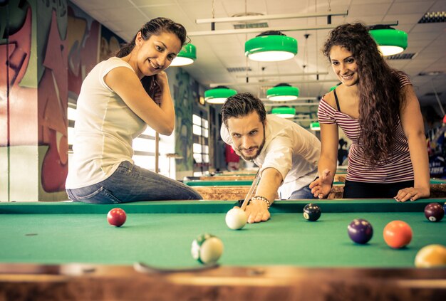 Amigos divirtiéndose en la sala de juegos de la piscina