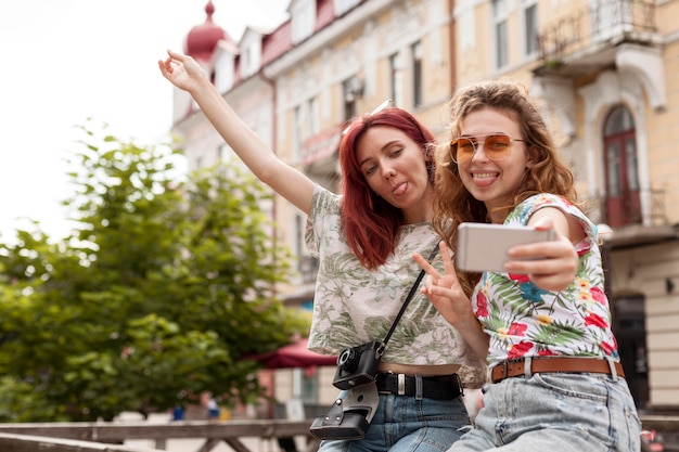 Foto amigos do meio tirando uma selfie no centro da cidade