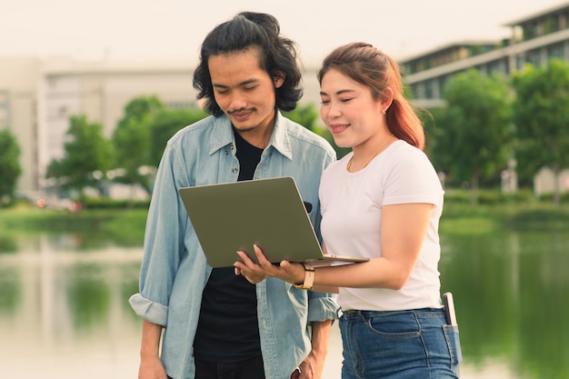 Amigos do povo asiático usando computador, laptop, verão, ao ar livre, na universidade