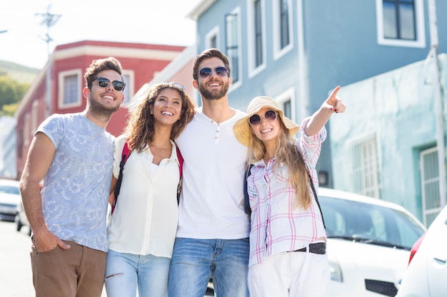 Amigos do quadril na cidade apontando para algum lugar