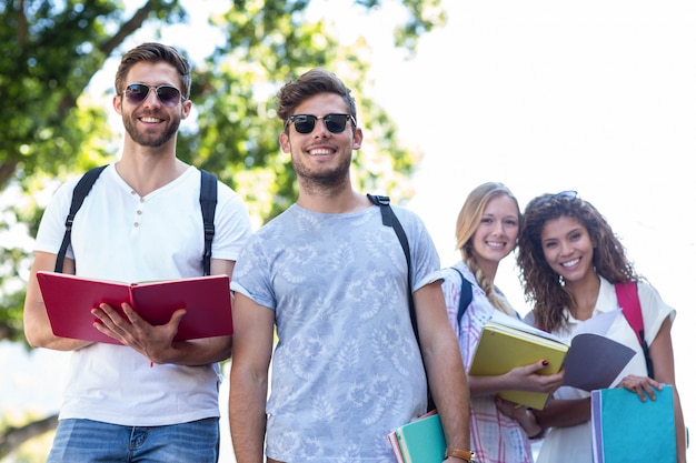 Amigos do quadril que leem notas em cadernos fora