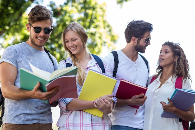 Amigos do quadril que leem notas em cadernos fora