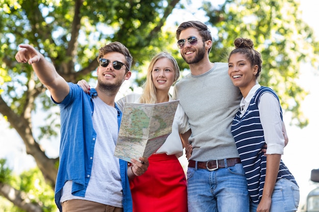 Amigos do quadril verificando o mapa e apontando em algum lugar