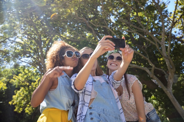 Foto amigos do sexo feminino tomando selfie com telefone móvel