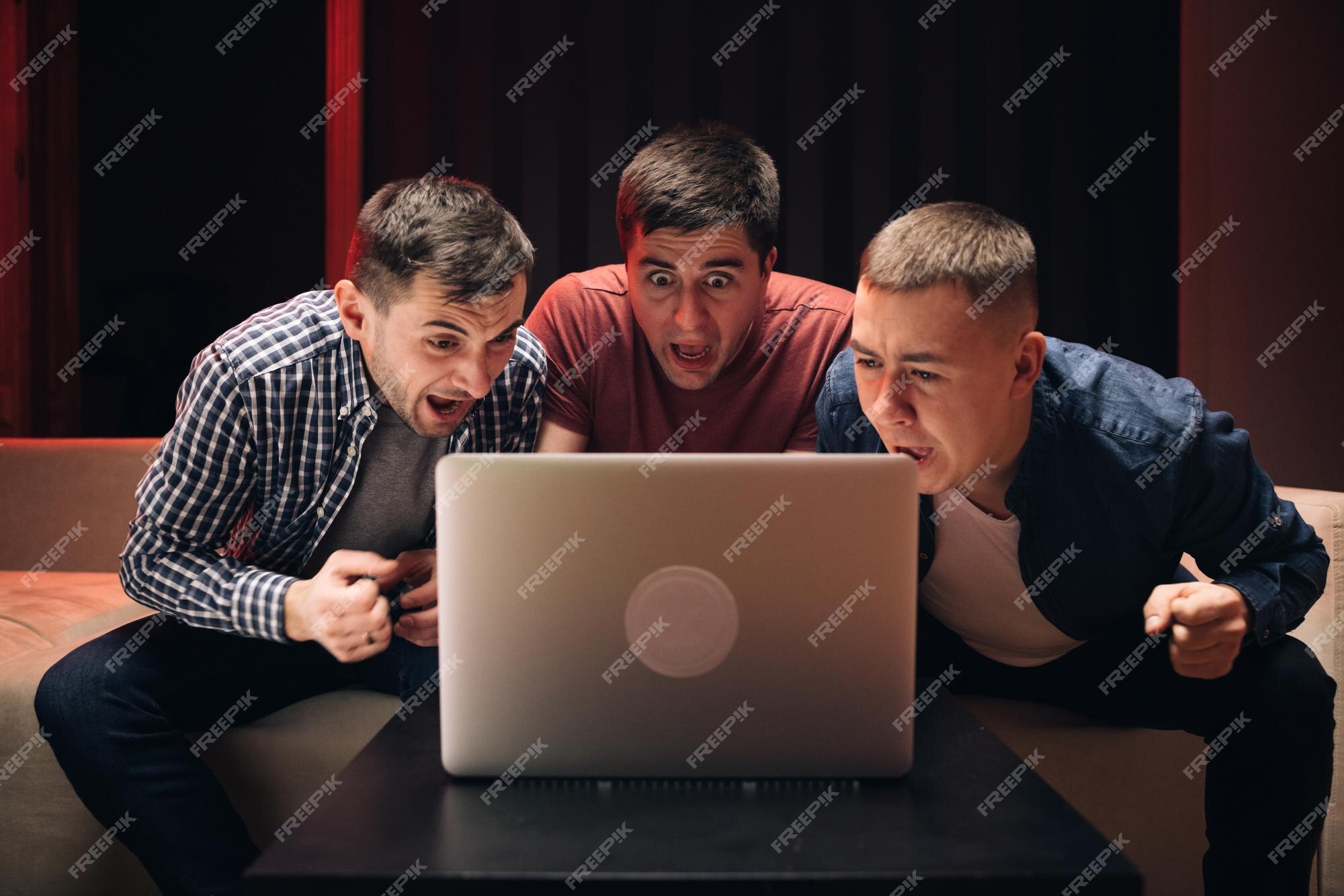 Amigos do sexo masculino assistindo jogo de futebol online no laptop homens  assistindo futebol em streaming