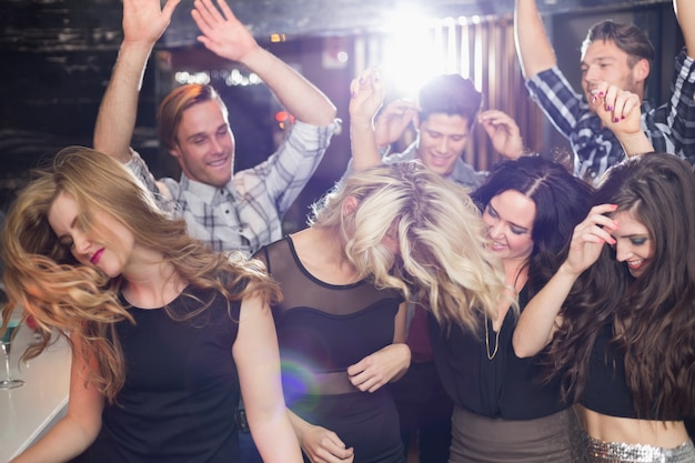 Amigos elegantes bailando y sonriendo