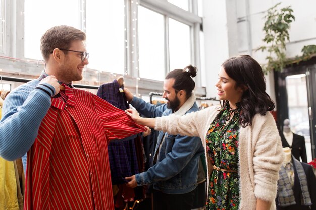 Foto amigos eligiendo ropa en una tienda de ropa vintage