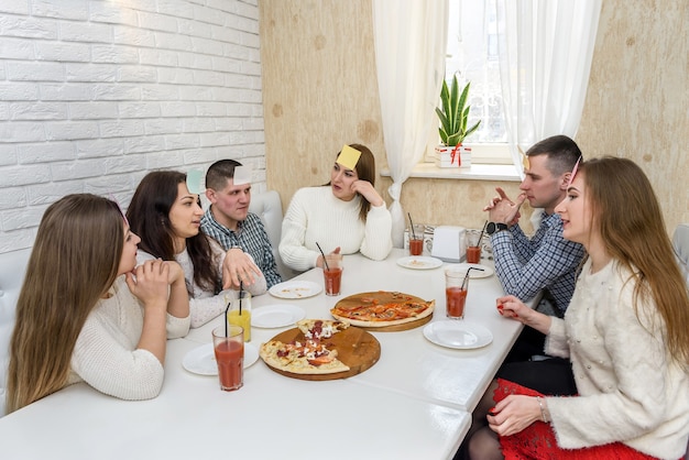 Amigos em um café comendo pizza e posando para a câmera