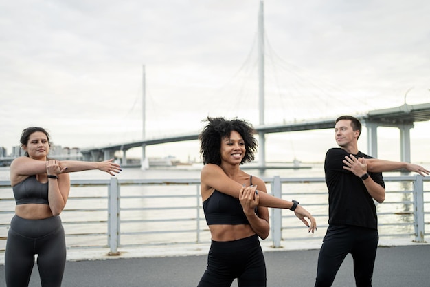 Los amigos están haciendo un entrenamiento de fitness en la ciudad Un grupo de personas son corredores en ropa deportiva