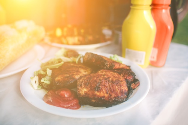 Foto amigos fazendo churrasco e almoçando na natureza. casal se divertindo enquanto comia e bebia em um piquenique - pessoas felizes na festa de churrasco