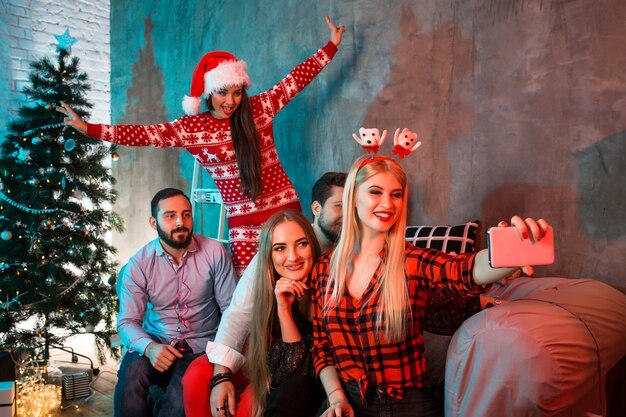 Amigos fazendo selfie enquanto comemoram o natal ou a véspera de ano novo em casa