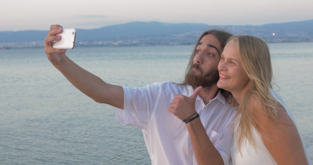 Amigos fazendo selfie feliz e positiva na praia