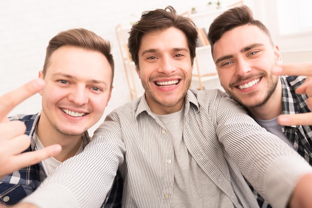 Amigos fazendo selfie gesticulando sinal de rock and roll