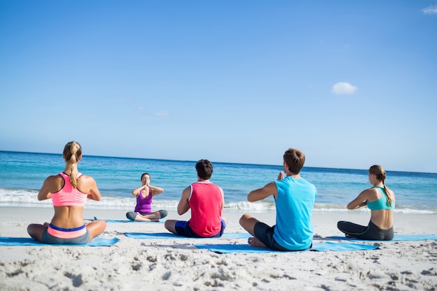 Amigos fazendo yoga junto com o professor