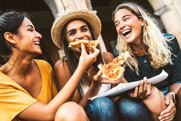 Amigos felices comiendo comida callejera en vacaciones de verano