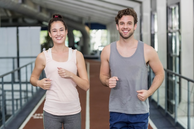 Amigos felices corriendo juntos en la pista