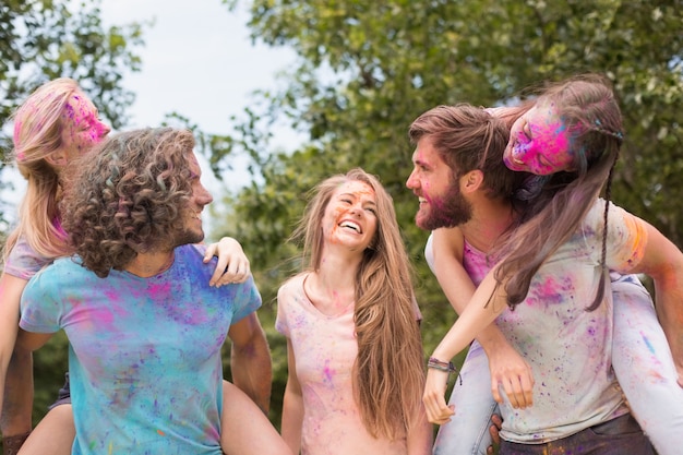 Foto amigos felices cubiertos de pintura en polvo