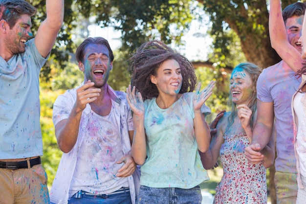 Amigos felices cubiertos de pintura en polvo