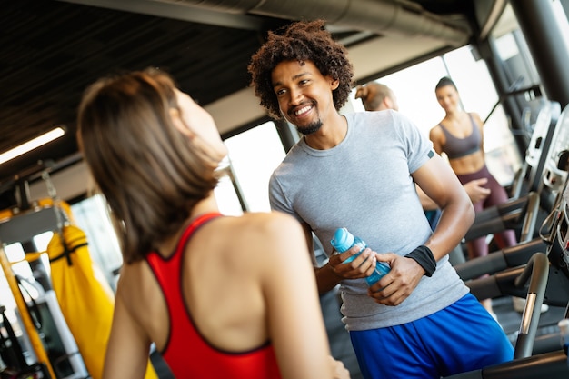 Amigos felices disfrutando de un descanso mientras charla en el gimnasio