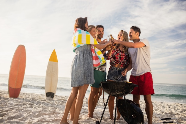 Amigos felices divirtiéndose alrededor de barbacoa