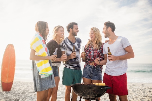 Amigos felices divirtiéndose alrededor de barbacoa