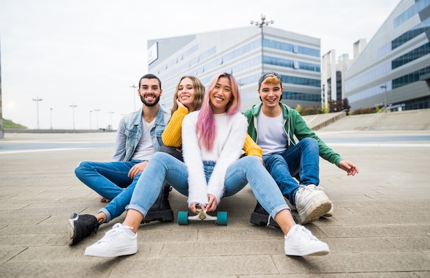 Amigos felices divirtiéndose en la ciudad sonriendo a la cámara