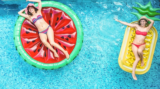 Foto amigos felices divirtiéndose dentro de la piscina durante las vacaciones de verano - centrarse en las caras