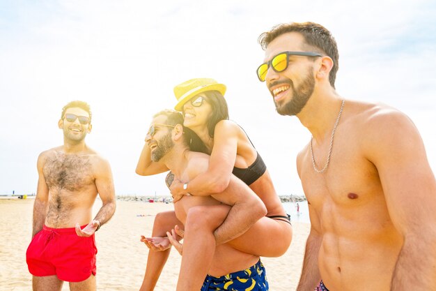 Amigos felices divirtiéndose en la playa de barcelona