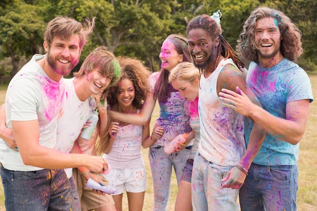 Foto amigos felices lanzando pintura en polvo