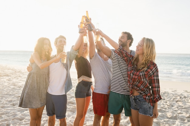 Amigos felices levantando botellas de cerveza