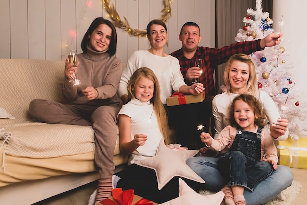 Los amigos felices con niños celebran la Navidad