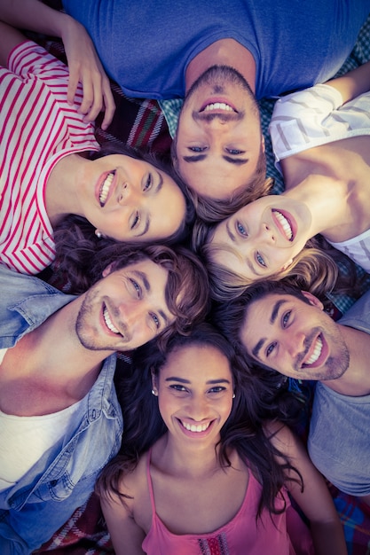 amigos felices en un parque acurrucado en círculo