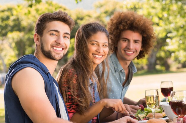 Amigos felices en el parque almorzando