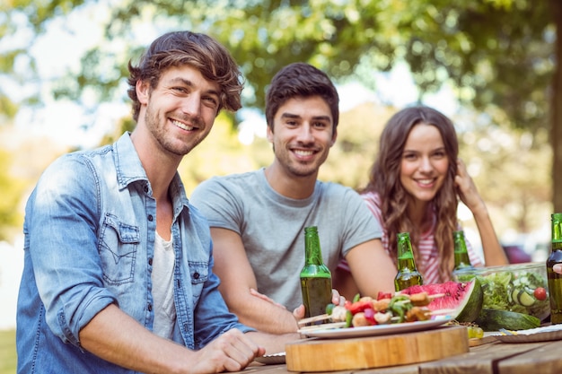 Amigos felices en el parque almorzando