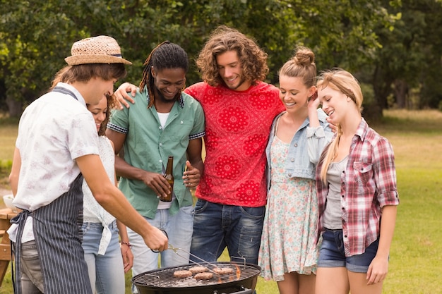 Foto amigos felices en el parque con barbacoa