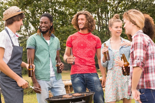 Amigos felices en el parque con barbacoa