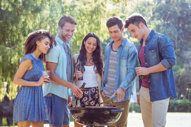 Amigos felices en el parque con barbacoa