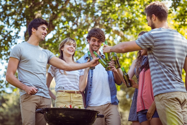 Amigos felices en el parque con barbacoa