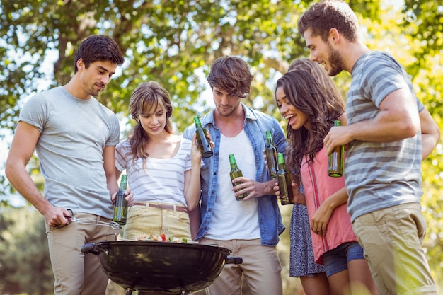 Amigos felices en el parque con barbacoa