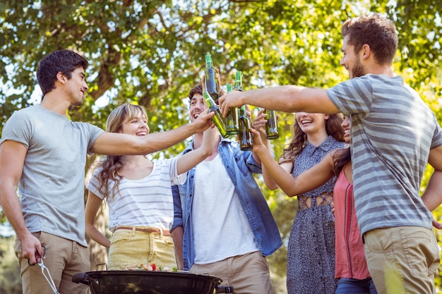 Amigos felices en el parque con barbacoa