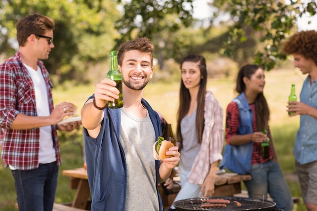 Amigos felices en el parque con barbacoa