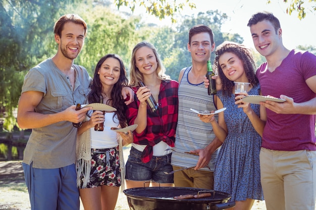 Amigos felices en el parque con barbacoa