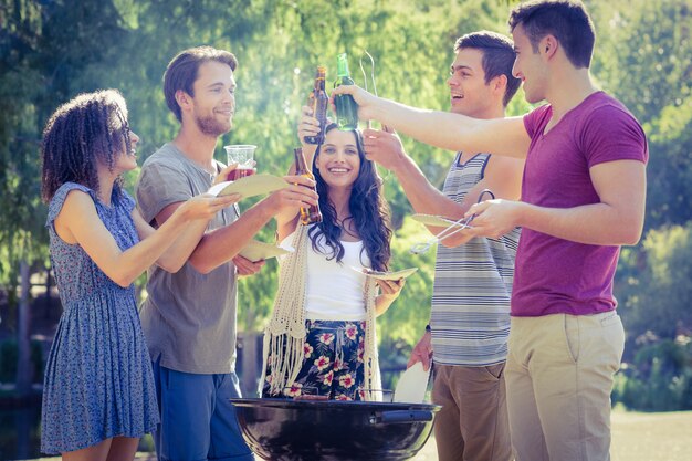 Amigos felices en el parque con barbacoa