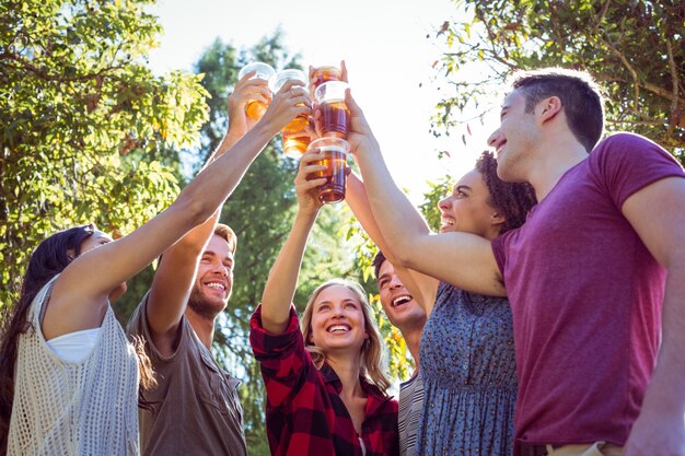 Amigos felices en el parque con cervezas