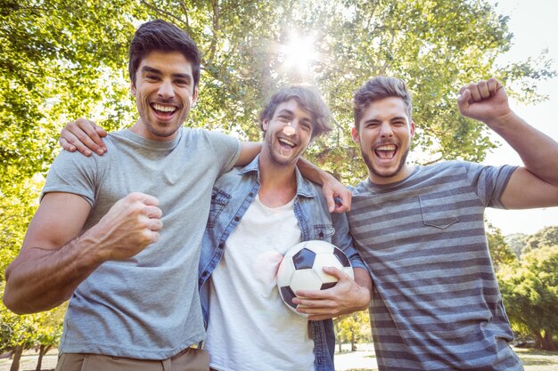 Foto amigos felices en el parque con fútbol